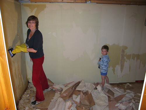 Removing old wallpaper and preparing wall with a scraper; photo courtesy Anette Snarby